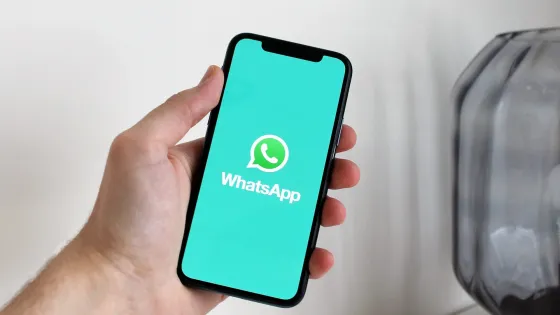 Mano sostiene celular que en su pantalla tiene el logro de WhatsApp